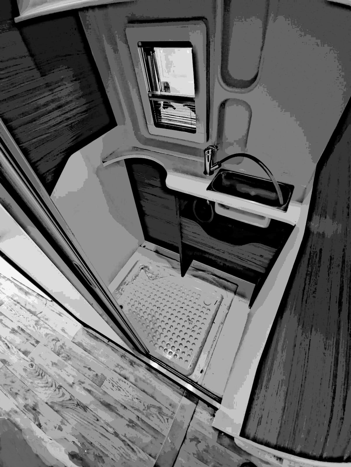 Foto reale del bagno installato del kit Campee OpenLoad per camper van Ducato L3H2, con finiture in legno nobilitato e pareti modulari impermeabili